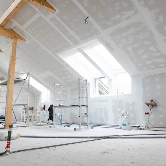Attic finishing construction site in the phase drywall spackling and plastering before screeding