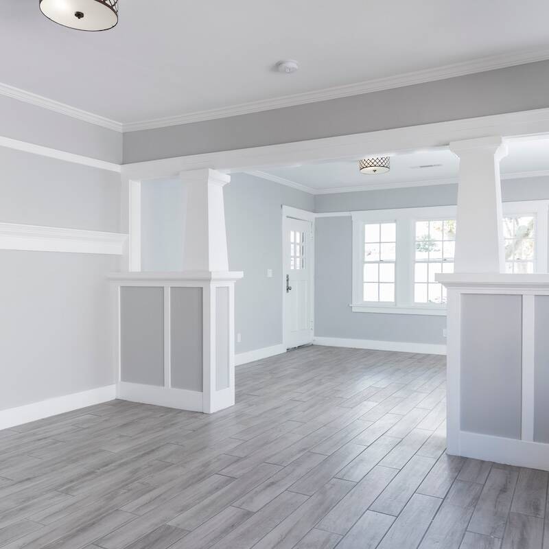 Living Room interior after remodelling with fire place and grey wooden floor.