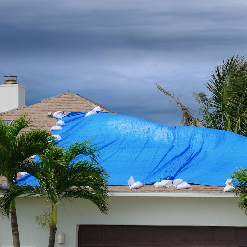 Storm damaged house with protective tarp